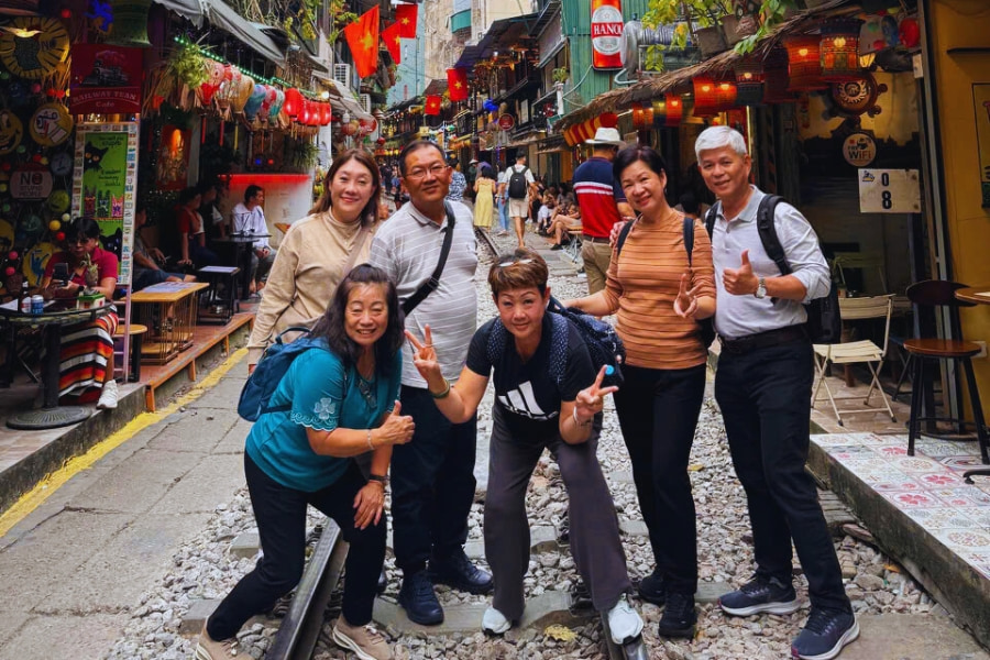 Travel group exploring Hanoi Train Street with Auasia Travel city tour